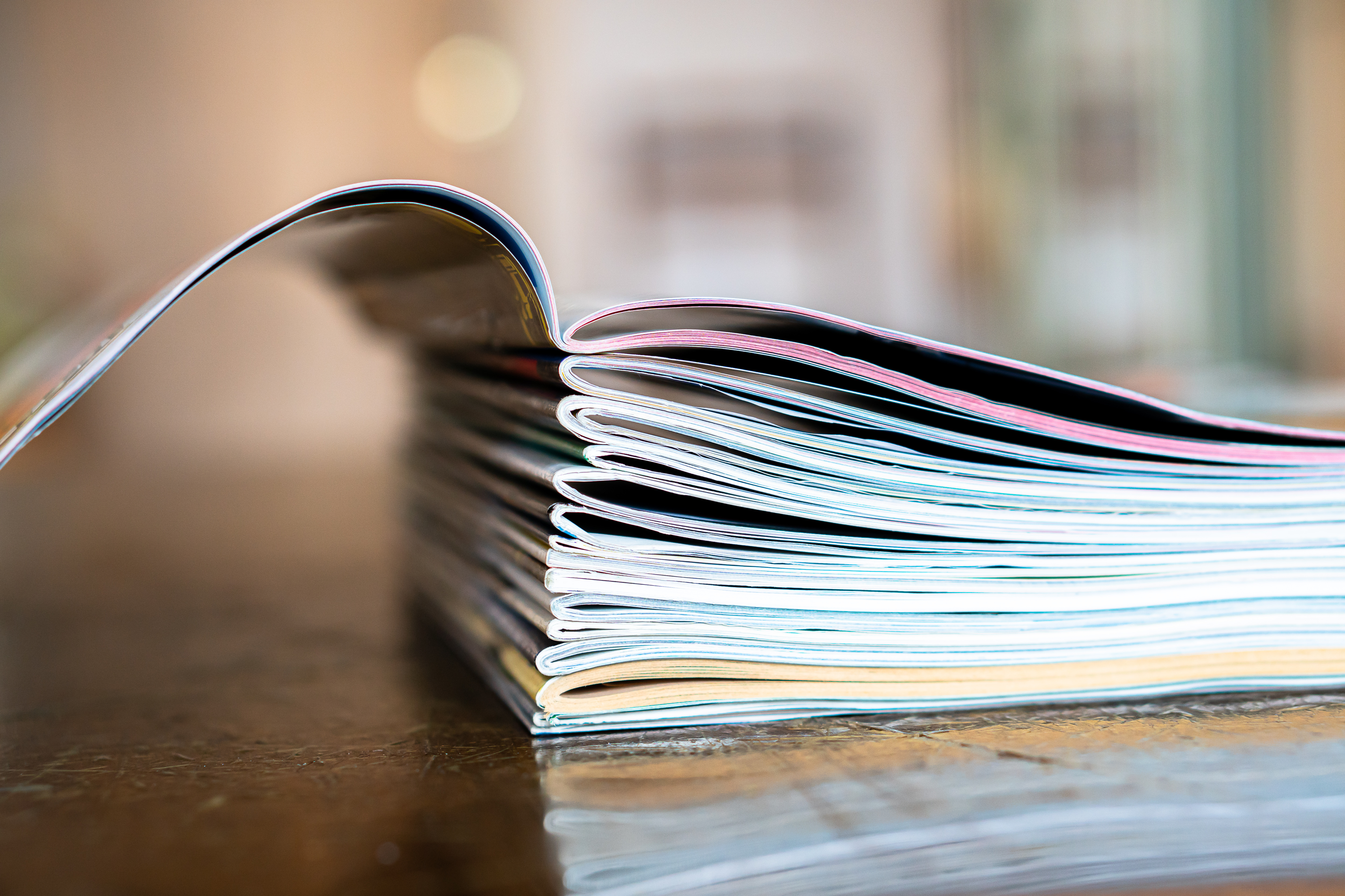 Nahaufnahme von einem Stapel alter Zeitschriften. Das erste Magazin ist aufgeschlagen.